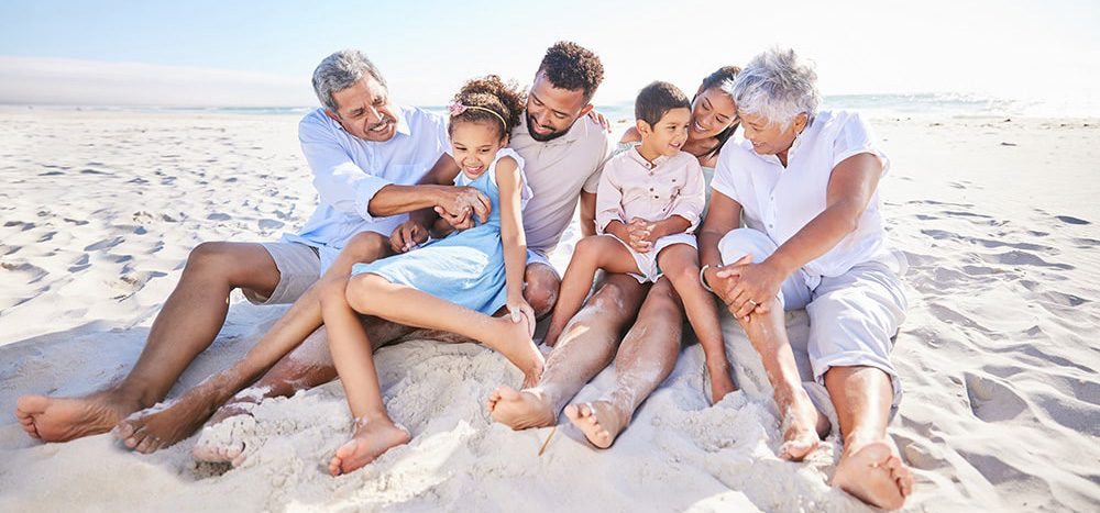 Family sitting on the sand while spending time together on the beach